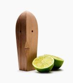 A wooden figure with two limes next to it.