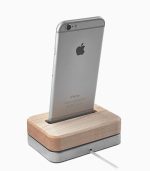 A silver iphone is on the wooden dock.