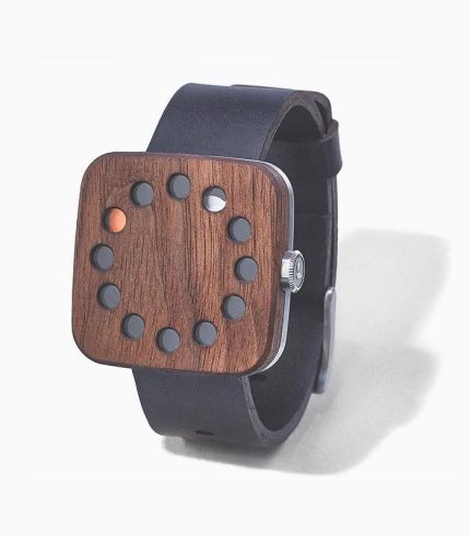 A wooden watch with holes on the face.