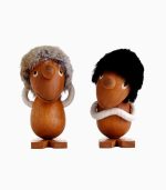 Two wooden figurines with fur hats on them.