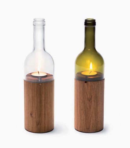 Two wine bottles with a candle inside of them.
