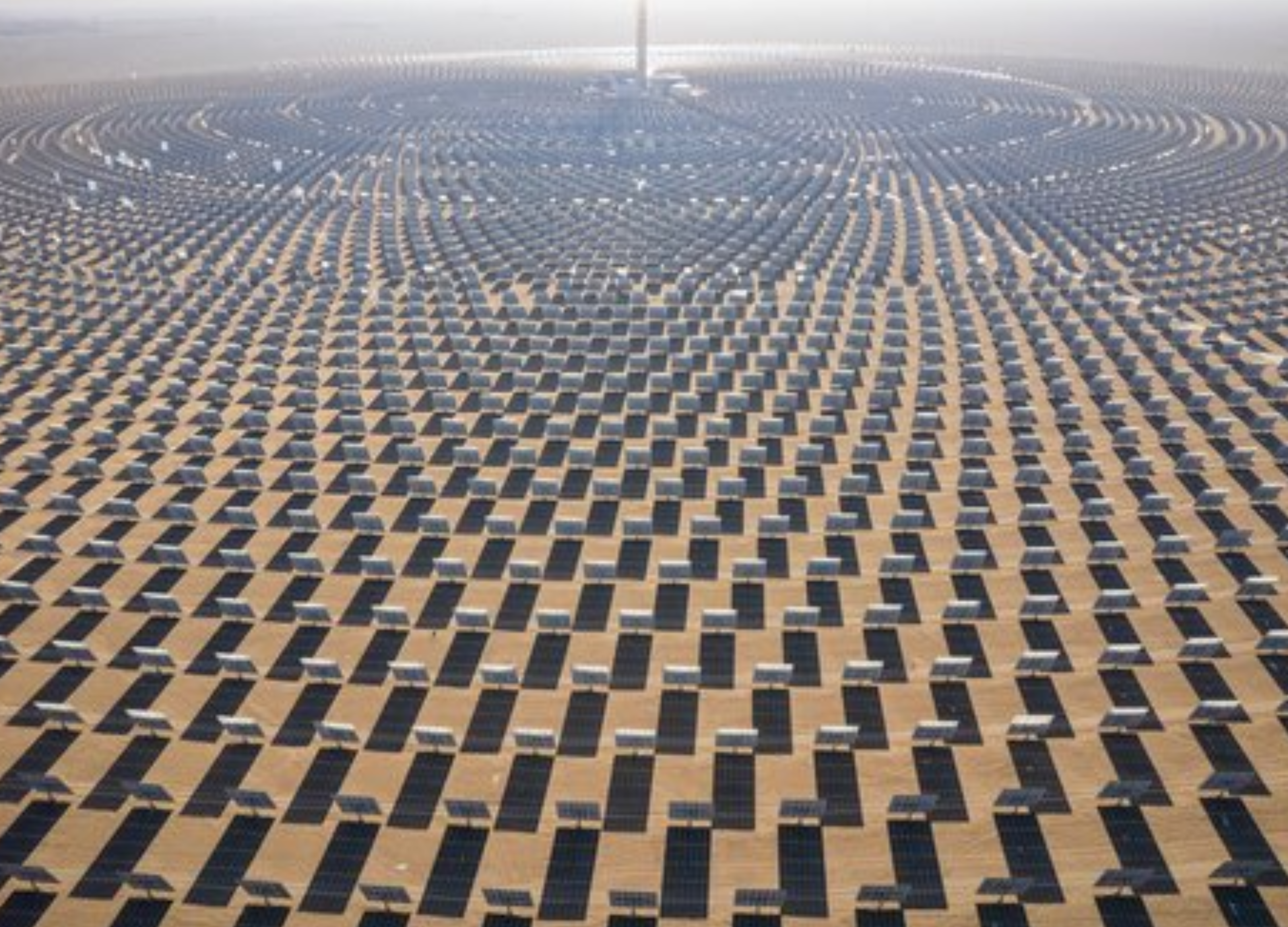 A large field of solar panels in the desert.